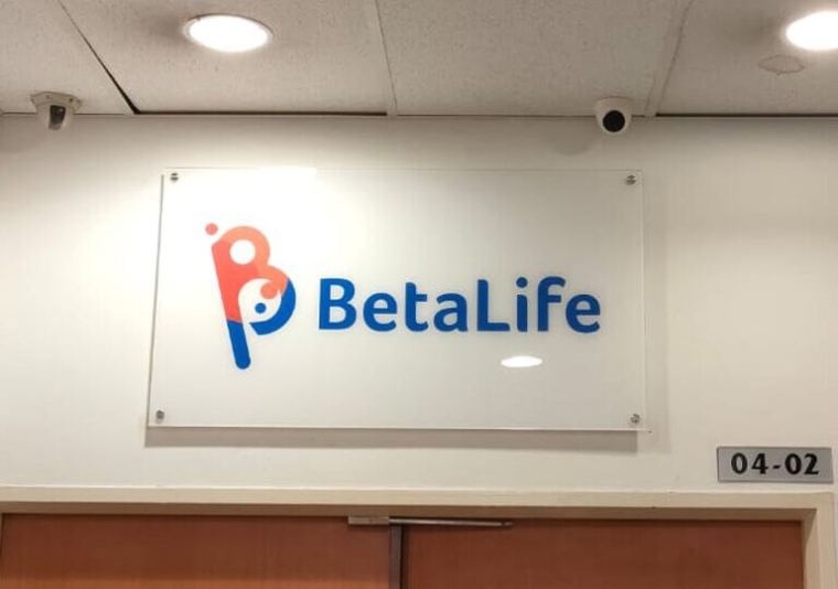 Acrylic office reception signage with company logo on a white wall