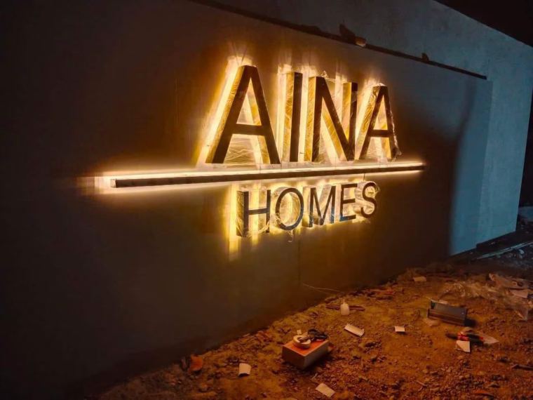 Halo-lit LED channel letters glowing warm white on a building wall