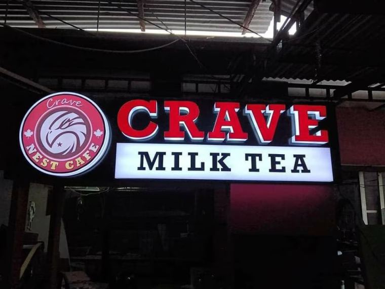 LED acrylic sign board for a cafe glowing at night